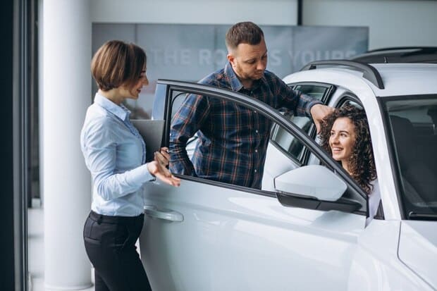 vendedora apresentando carro para casal